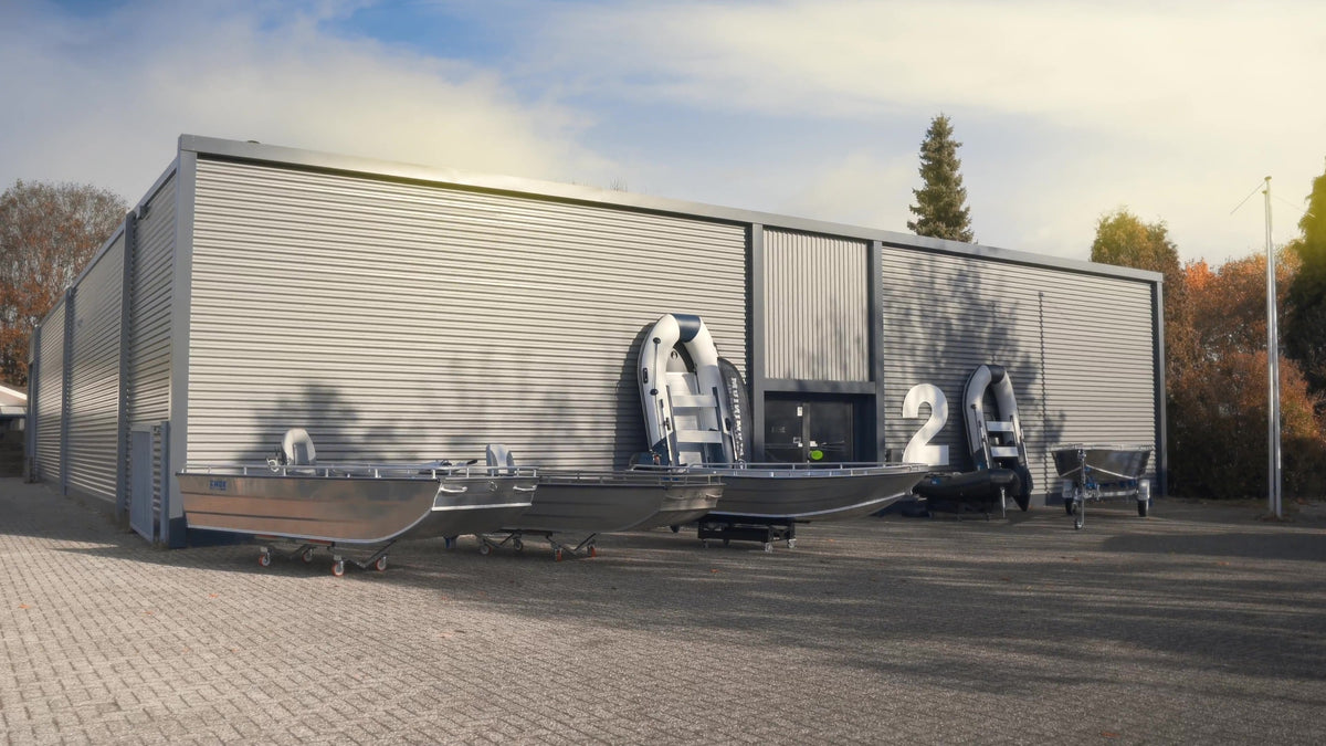 Bedrijfspand met rubberboten en aluminium boten voor de ingang.
